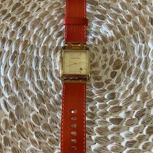 Michael Kohl’s gold watch with orange leather band